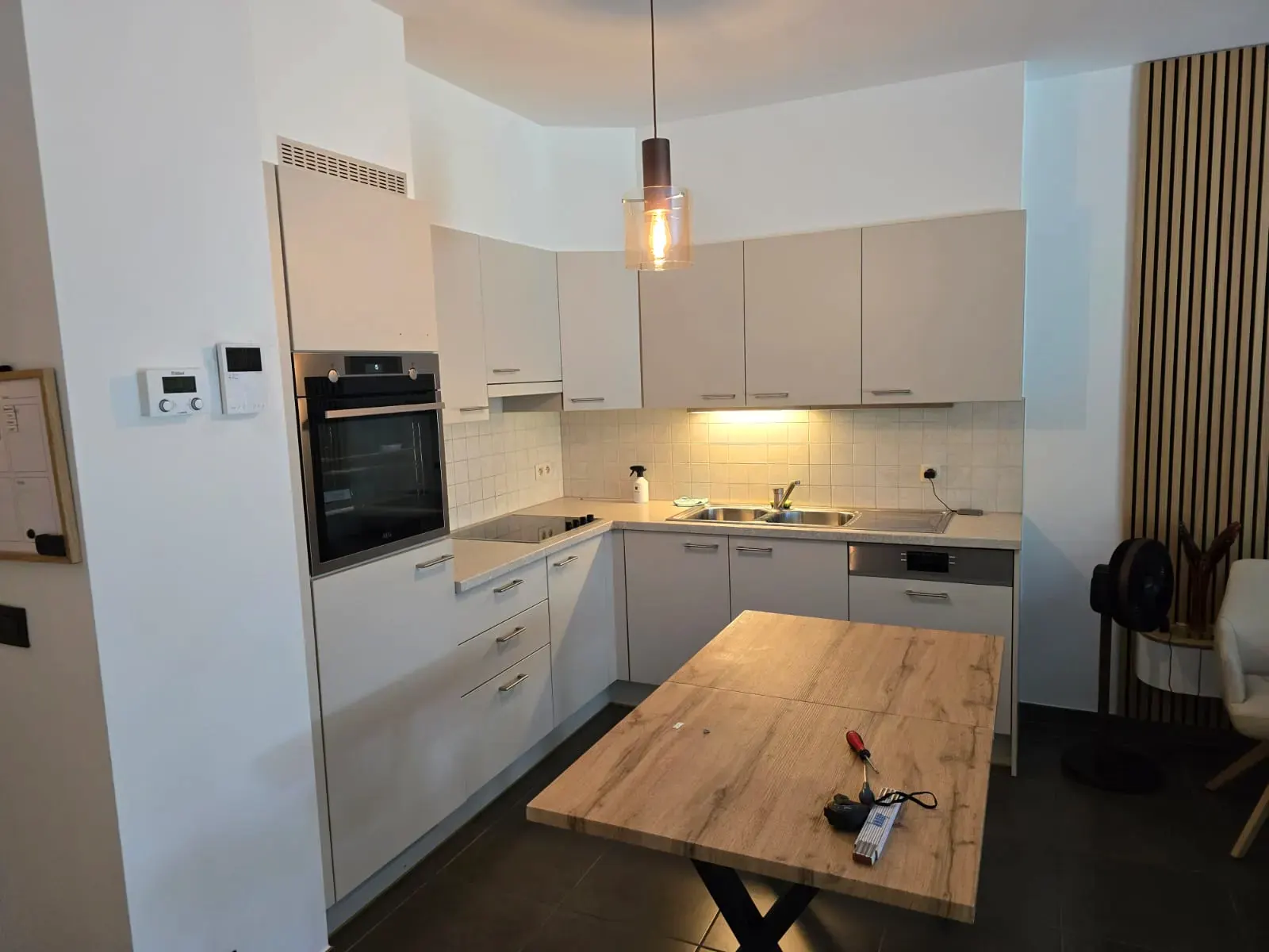Keuken met beige tegels en witte kastfronten, voor de wrapping