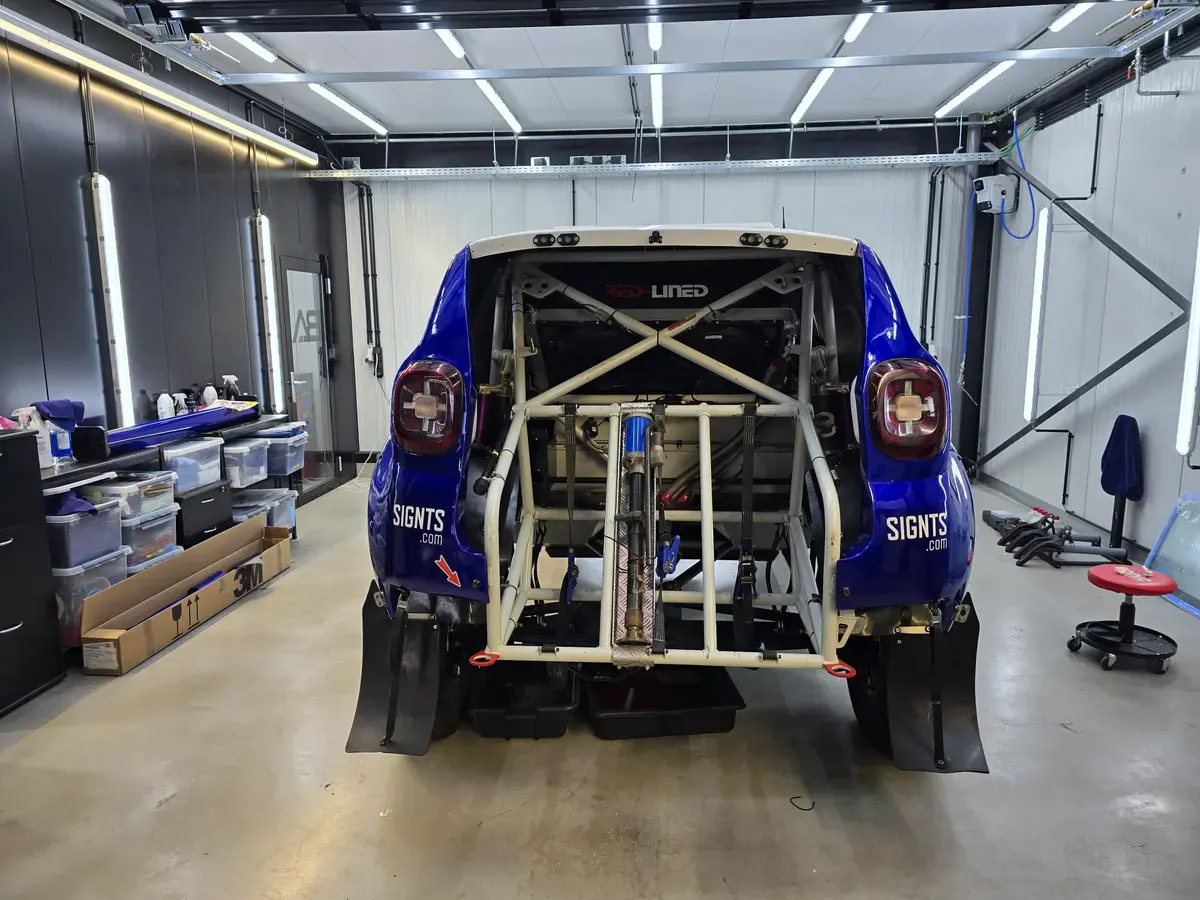 Dacia Duster rally build met blauw/witte wrap en rolkooi